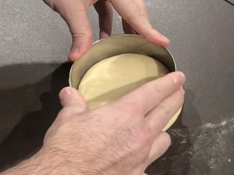 Un disque de pâte à beignets est détaillé à l'aide d'un cercle à mousse