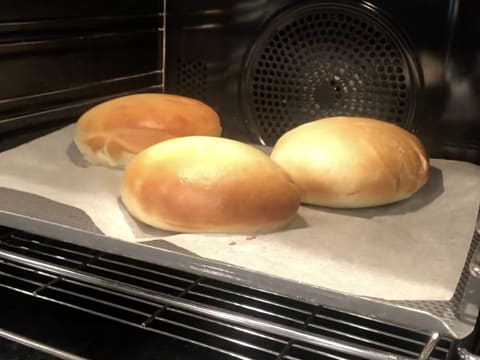 Les trois beignets sont en train de cuire et de dorer dans le four à mi hauteur