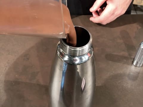 La préparation chocolatée est versée dans un siphon chantilly