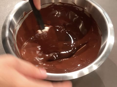 Mélange du chocolat noir fondu avec le beurre de cacao Mycryo à l'aide de la spatule maryse dans le cul de poule