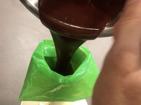 Le chocolat noir fondu et tempéré est débarrassé dans une poche à douille