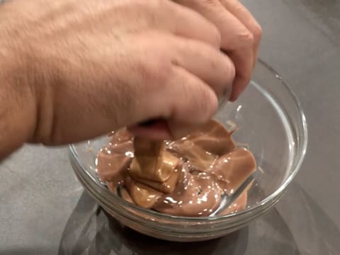 Ajout du praliné amandes/noisettes dans le chocolat au lait fondu qui est dans le saladier