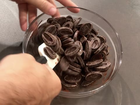 Mélange du chocolat noir qui est en train de fondre dans le saladier, à l'aide de la spatule type maryse