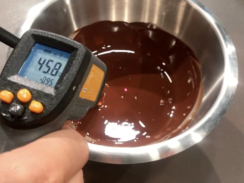 Prise de la température du chocolat noir fondu dans le cul de poule, celui-ci titre 45,8°C