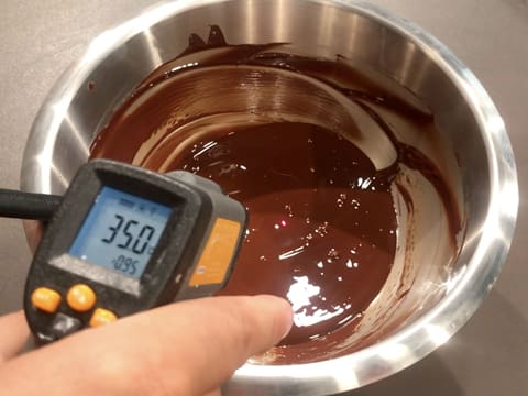 Prise de la température du chocolat noir fondu dans le cul de poule, celui-ci titre 35,0°C