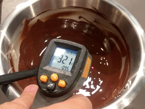 Prise de la température du chocolat noir fondu dans le cul de poule, celui-ci titre 32,1°C