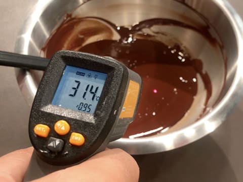 Prise de la température du chocolat noir fondu dans le cul de poule, celui-ci titre 31,4°C