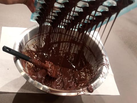 Le moule chocolat demi-sphère est retourné au-dessus du cul de poule et le chocolat coule dans ce dernier