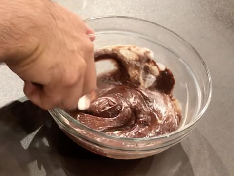 Mélange et incorporation de la crème de coco dans la préparation chocolatée dans le saladier, à l'aide de la spatule maryse