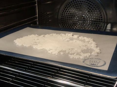 La pâte à la noix de coco étalée sur un tapis de cuisson en silicone est placée dans le four