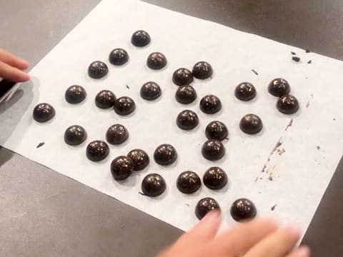 Obtention des demi-sphères en chocolat démoulées sur la feuille de papier sulfurisé