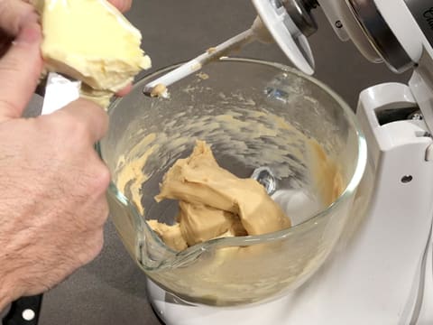 Ajout du beurre coupé en morceaux sur la pâte dans la cuve du batteur muni de l'accessoire crochet