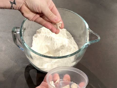 La levure de boulanger fraîche est émiettée sur la farine dans la cuve du batteur