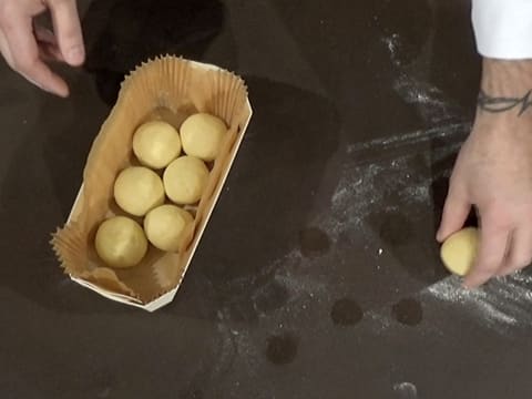 Les boules de pâte sont déposées dans la barquette en bois