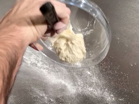 La pâte contenue dans le saladier est débarrassée sur le plan de travail légèrement fariné