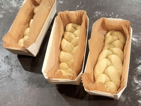 Obtention de trois brioches vendéennes tressées dans leur barquette de cuisson en bois sur le plan de travail