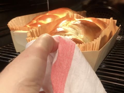 Une des brioches est en train d'être sortie du four, pendant qu'une autre est encore dedans