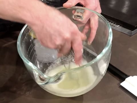 Les blancs d'oeufs et le sucre en poudre sont mélangés ensemble à l'aide d'un fouet à main, dans la cuve du batteur