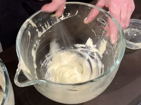 Le beurre fondu et la préparation à base des poudres, oeufs battus et blancs en neige sont mélangés au fouet à main, dans la cuve du batteur