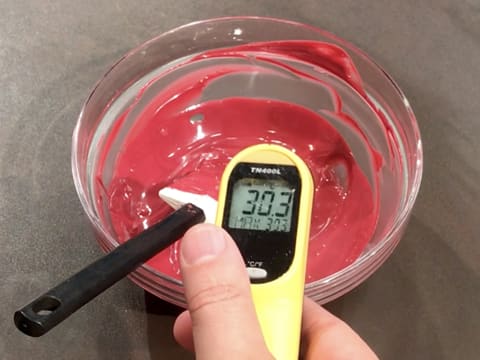 Prise de la température du chocolat à la framboise fondu dans le saladier, qui titre 30,3°C