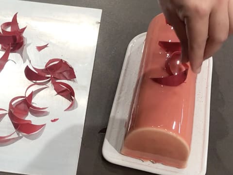 Les décors en chocolat à la framboise sont disposés sur la bûche glacée