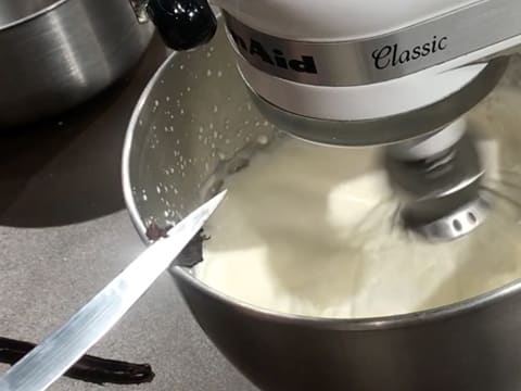 Ajout des grains de vanille dans la crème qui est en train d'être fouettée au batteur électrique