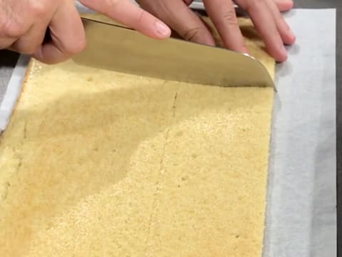 Découpe d'un côté de la bande de biscuit avec un couteau