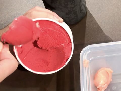 Prélèvement d'une cuillère à soupe de sorbet framboise