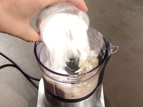 Ajout du sucre glace dans la cuve du mixeur, sur la poudre d'amandes