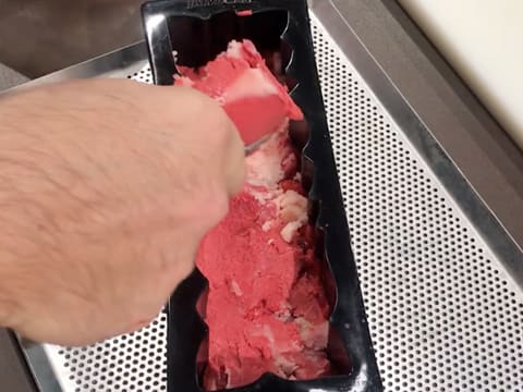 Du sorbet litchi et framboise est étalé dans le moule à bûche silicone