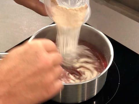 Ajout du mélange pectine NH nappage et sucre en poudre dans la purée de framboise, tout en mélangeant au fouet