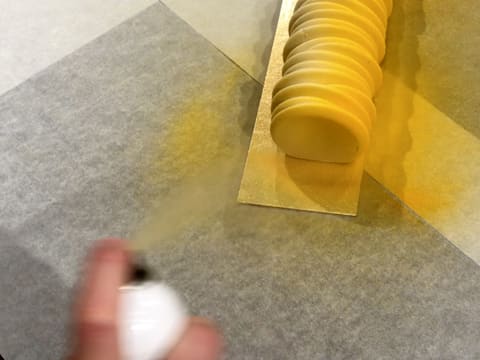 Pulvérisation du colorant en spray effet velours jaune sur la première extrémité de la bûche