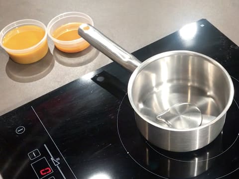 Le sirop de glucose est versé dans la casserole qui est placée sur la plaque de cuisson