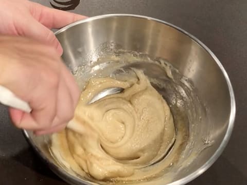 Mélange de la préparation à base de poudres, de blancs d'œufs et de beurre noisette dans le cul de poule