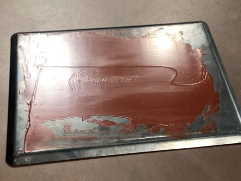 Le chocolat fondu se cristallise sur la plaque à pâtisserie