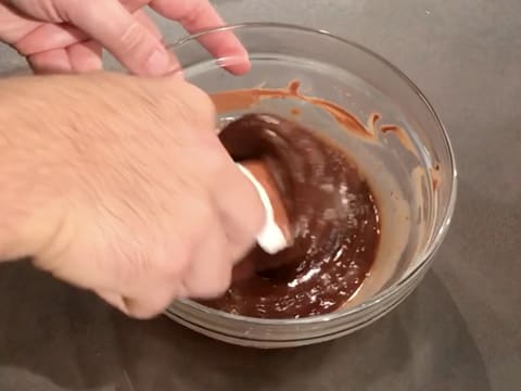 Le lait est incorporé dans le chocolat fondu à l'aide de la spatule maryse