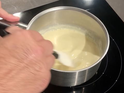 Cuisson de la crème anglaise dans la casserole tout en mélangeant avec la spatule maryse