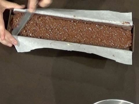 Le croustillant spéculoos est étalé dans le moule à bûche avec une petite spatule métallique coudée