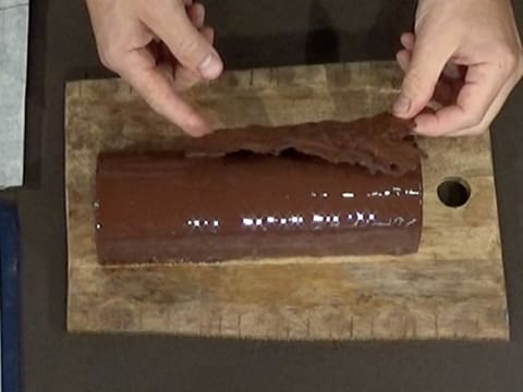 Une décoration en chocolat est déposée sur la bûche