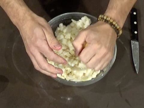 Un demi citron est pressé au-dessus du saladier en verre, sur les cubes de poire