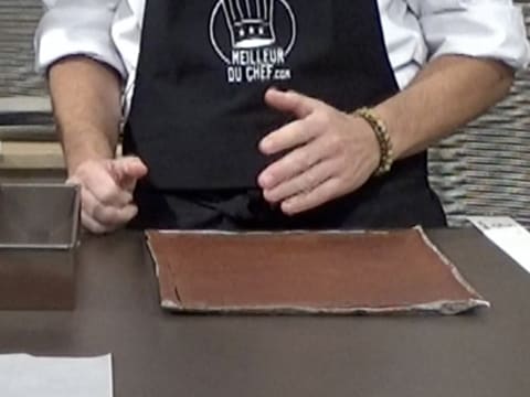 Le biscuit chocolat qui est sur la plaque à pâtisserie recouverte d'une feuille de papier sulfurisé, est placé sur le plan de travail