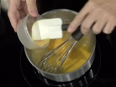 Ajout des oeufs entiers préalablement battus dans la casserole contenant la préparation à la poire précédemment mélangée au fouet