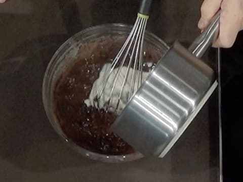 Du lait chaud contenu dans la casserole est versé sur les pistoles partiellement fondues dans la première partie de lait