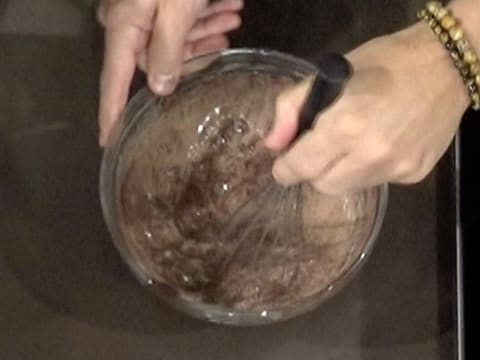 Mélange de la préparation chocolatée avec le fouet, dans le saladier en verre