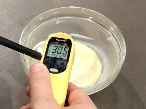 Prise de la température du chocolat blanc fondu dans le bol, qui titre 30,5°C, avec un thermomètre à visée laser