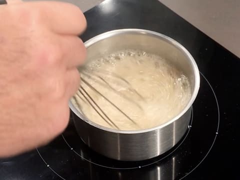 Mélange au fouet de la préparation au pamplemousse qui est en ébullition dans la casserole