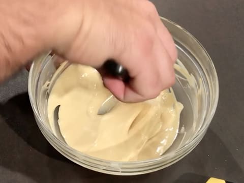 Mélange du chocolat blanc fondu et du colorant en poudre or avec la spatule maryse