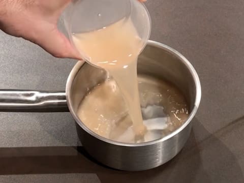 Du jus de pamplemousse est versé dans une casserole