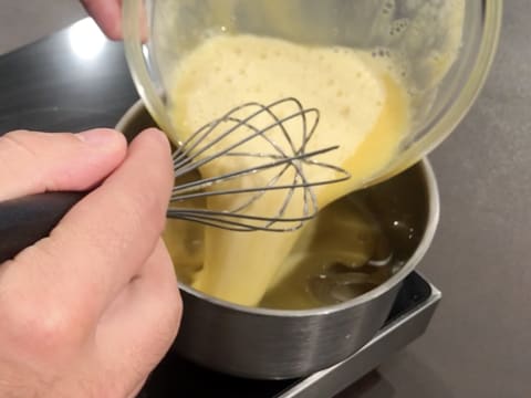 Le mélange de Champagne, jus de citron, jaunes d'oeufs et sucre est versé dans la casserole