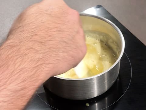 Cuisson de la préparation à base de Champagne, jus de citron, jaunes d'oeufs et sucre, dans la casserole